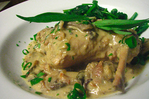 Мясо кролика с грибами и сметаной на тарелке